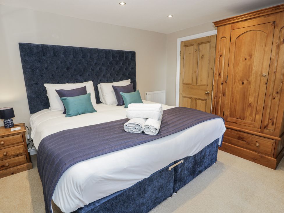 A bedroom with a bed and wardrobe at Tyddyn Goronwy in Talybont