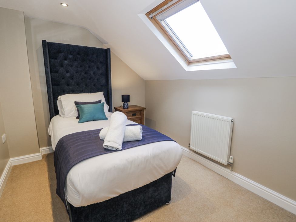A bedroom with a single bed and a skylight at Tyddyn Goronwy in Talybont