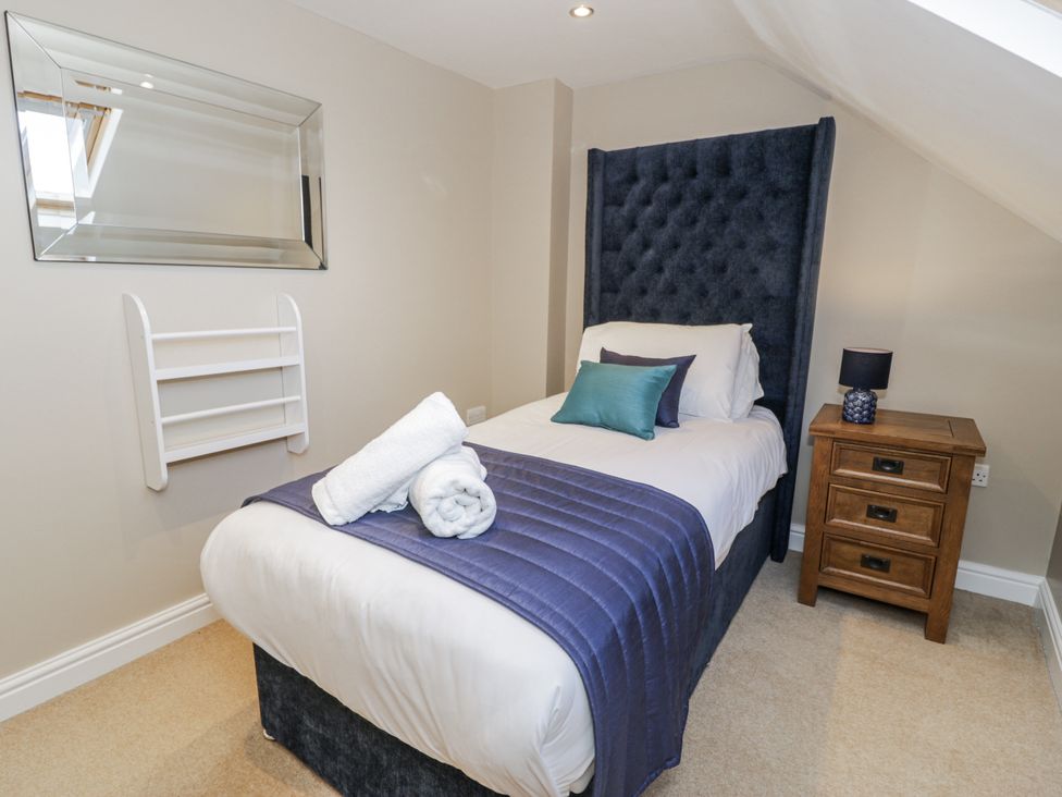 A bedroom with a single bed and bedside table at Tyddyn Goronwy in Talybont