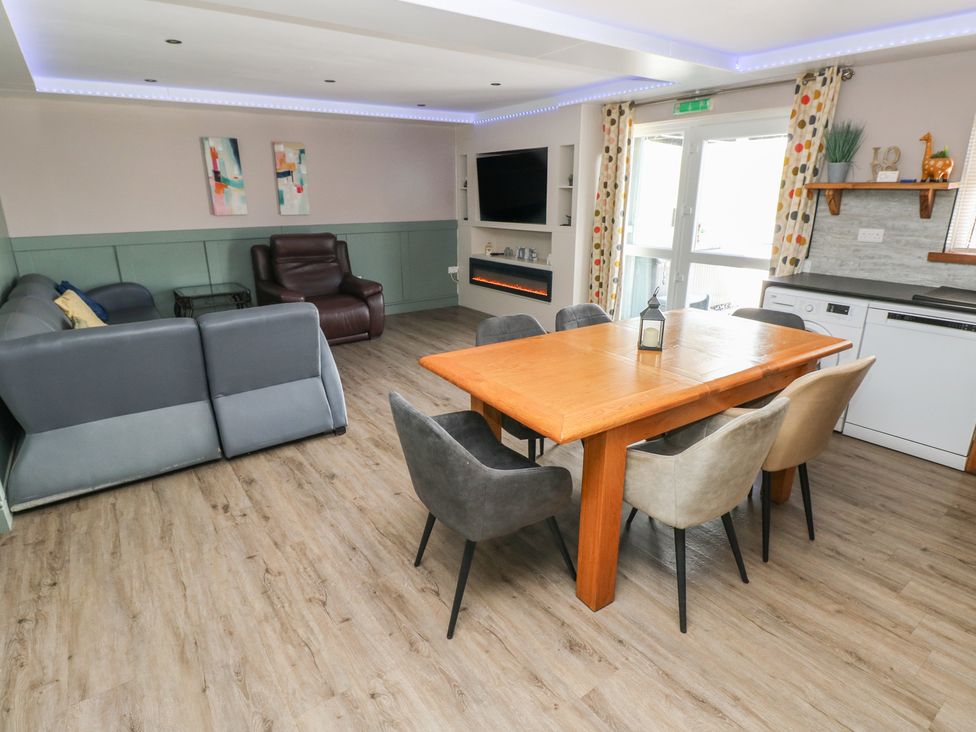 A living room with a sofa and dining area at Meadow View in Laugharne