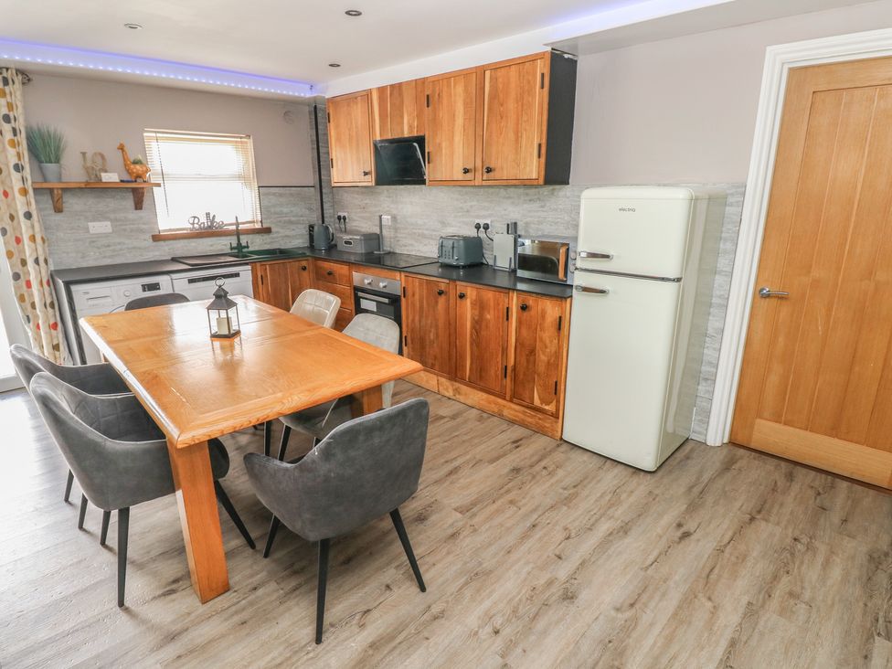 A kitchen with a dining table and chairs at Meadow View in Laugharne