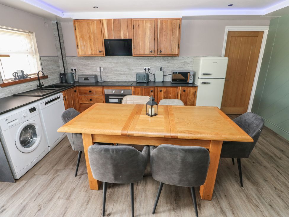 A kitchen with a table and chairs at Meadow View in Laugharne