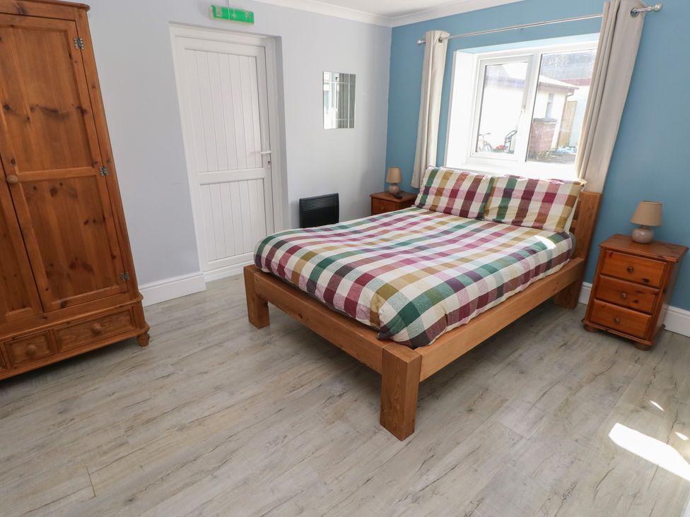 A bedroom with a bed and wardrobe at Meadow View in Laugharne
