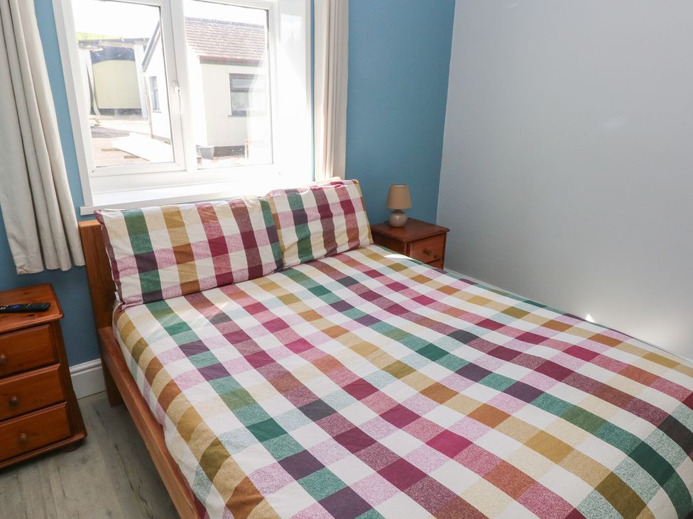 A bedroom with a bed and window at Meadow View in Laugharne