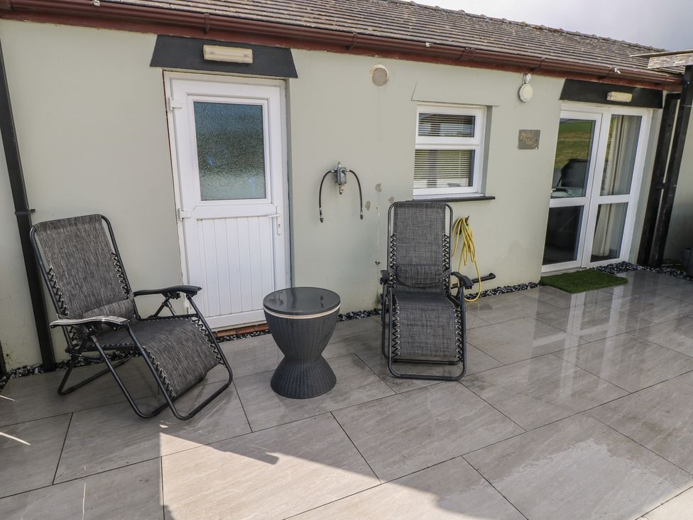 An outdoor area with seating and a table at Meadow View in Laugharne