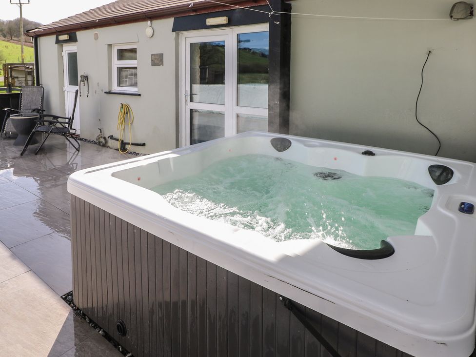 A hot tub with water in an outdoor area at Meadow View in Laugharne
