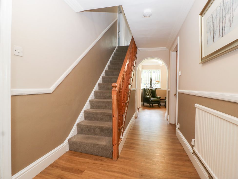 A hallway with a staircase and armchair at The Croft in Vowchurch near Peterchurch