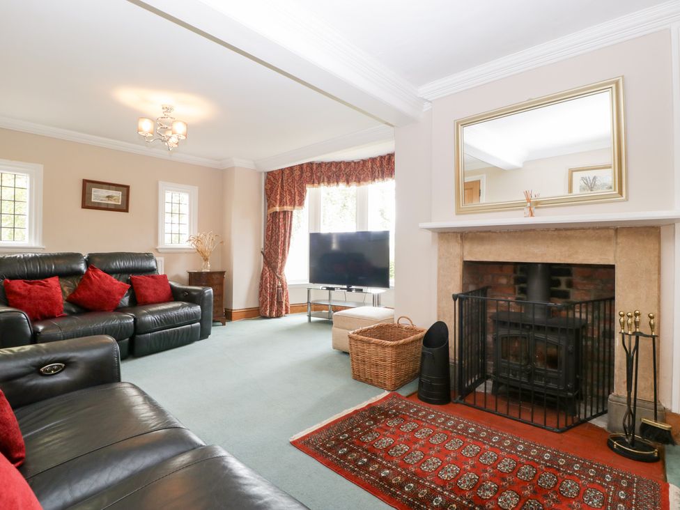A living room with a sofa, tv, and fireplace at The Croft in Vowchurch near Peterchurch