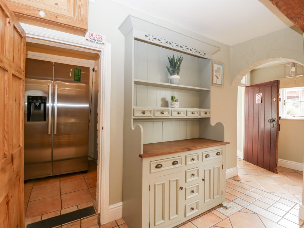 A kitchen with a refrigerator and a shelf with plants at The Croft in Vowchurch near Peterchurch