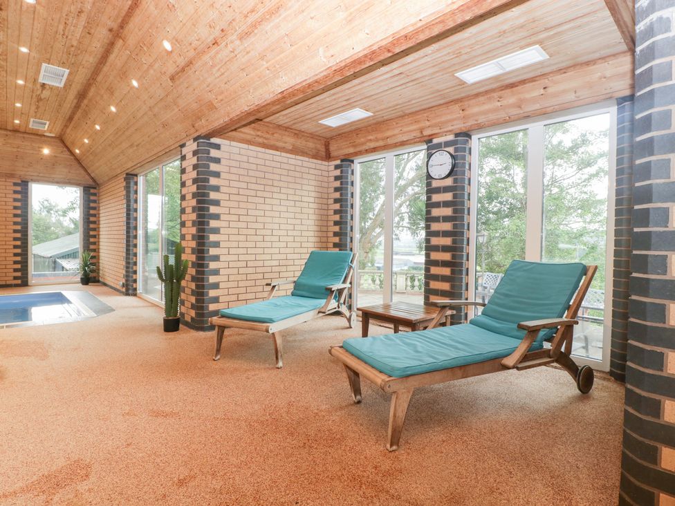 An indoor pool area with sun loungers at The Croft in Vowchurch near Peterchurch