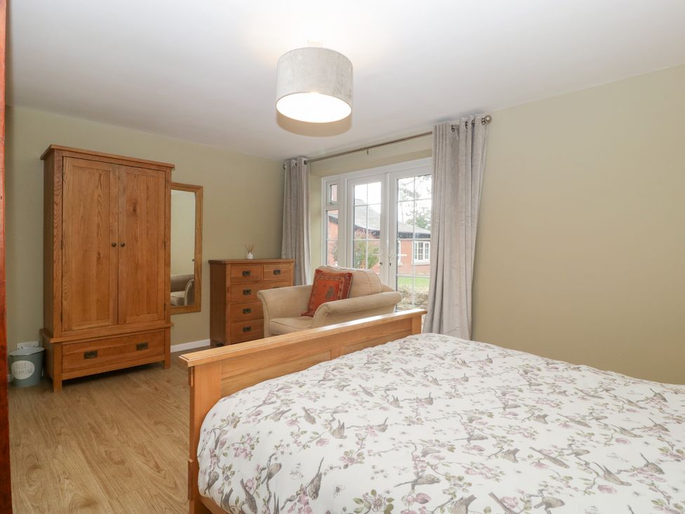 A bedroom with a bed and wooden furniture at The Croft in Vowchurch near Peterchurch