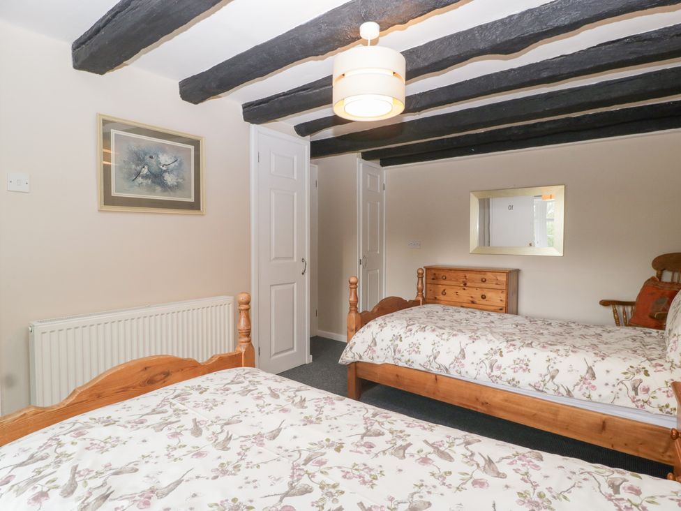 A bedroom with two beds and a mirror at The Croft in Vowchurch near Peterchurch