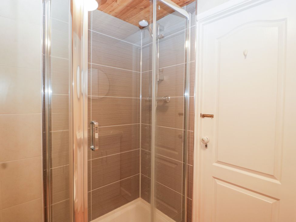 A shower with glass doors and tile walls at The Croft in Vowchurch near Peterchurch