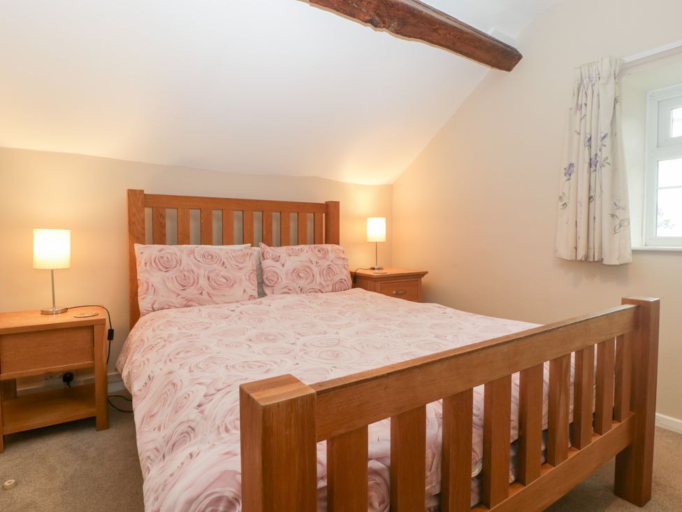 A bedroom with a wooden bed and bedside lamps at The Croft in Vowchurch near Peterchurch