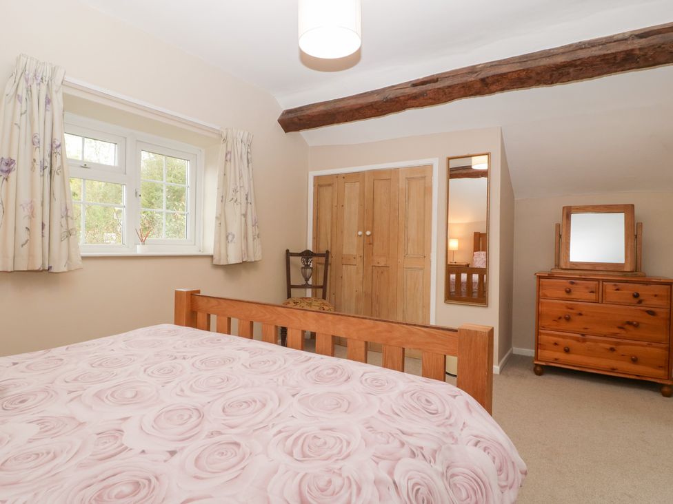 A bedroom with a bed, wardrobe, and window at The Croft in Vowchurch near Peterchurch