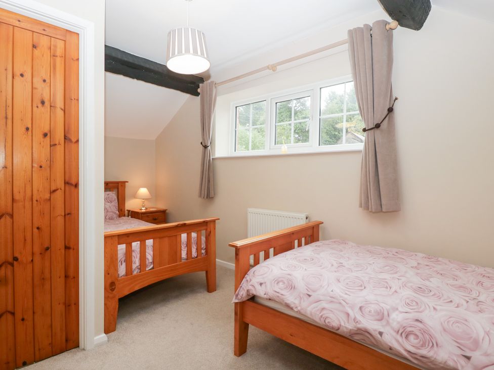 A bedroom with two beds and a bedside table at The Croft in Vowchurch near Peterchurch
