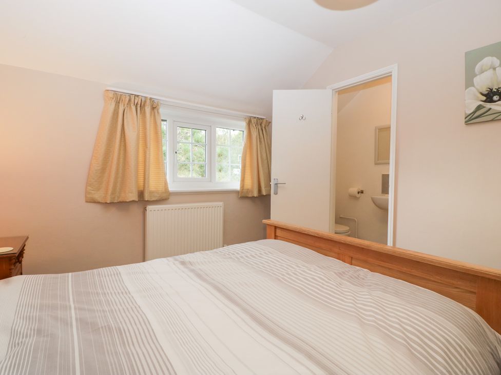 A bedroom with a double bed and a door leading to a bathroom at The Croft in Vowchurch near Peterchurch
