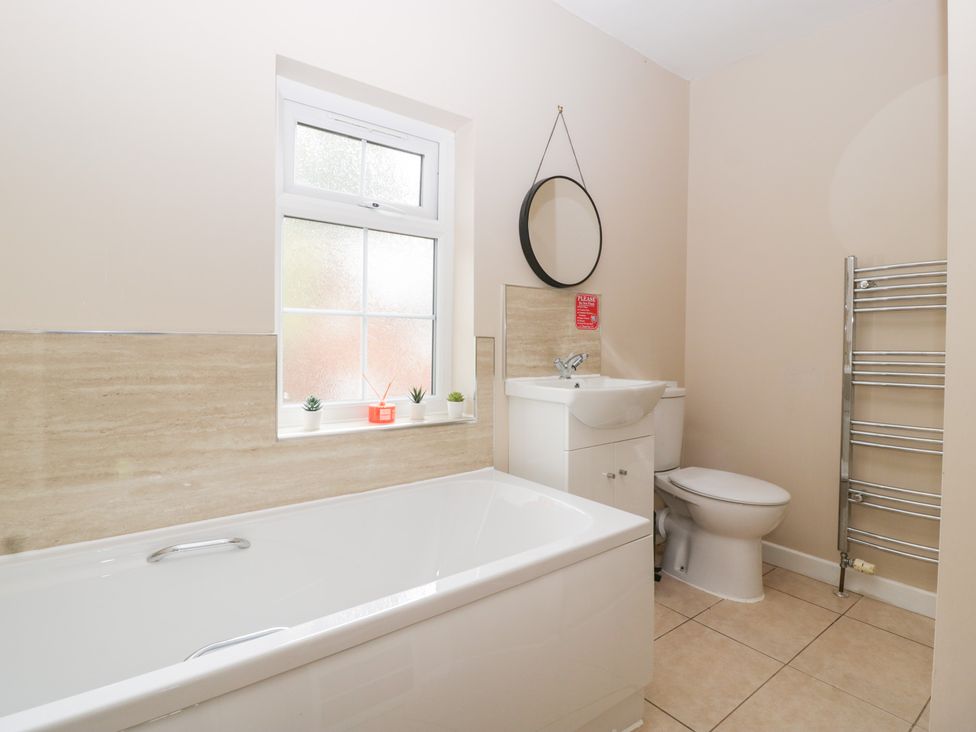 A bathroom with a bathtub, sink, toilet and window at The Croft in Vowchurch near Peterchurch