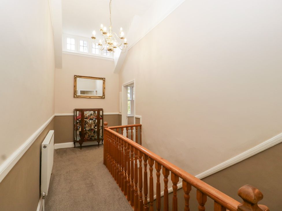 A hallway with a chandelier and staircase at The Croft in Vowchurch near Peterchurch