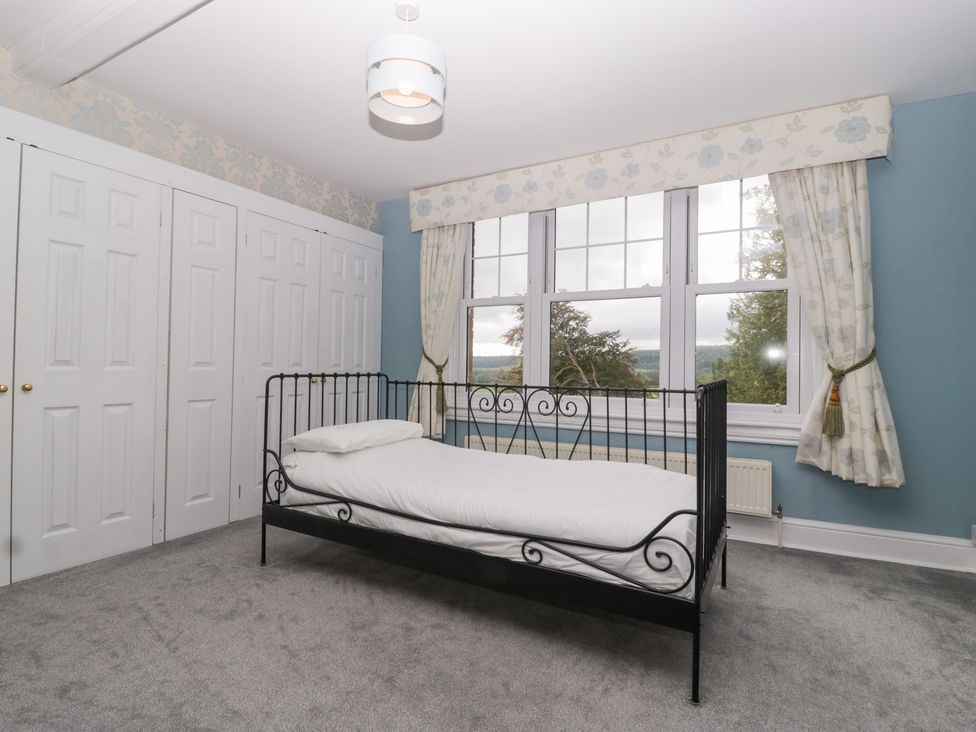 A bedroom with a single bed and large windows at The Croft in Vowchurch near Peterchurch