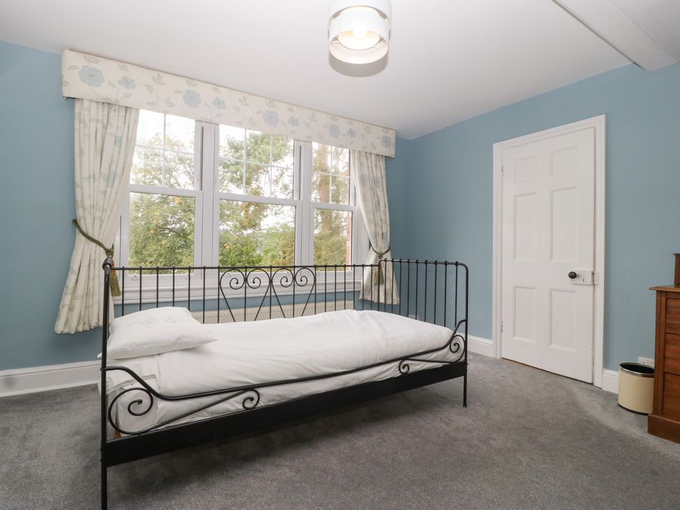 A bedroom with a bed and windows at The Croft in Vowchurch near Peterchurch
