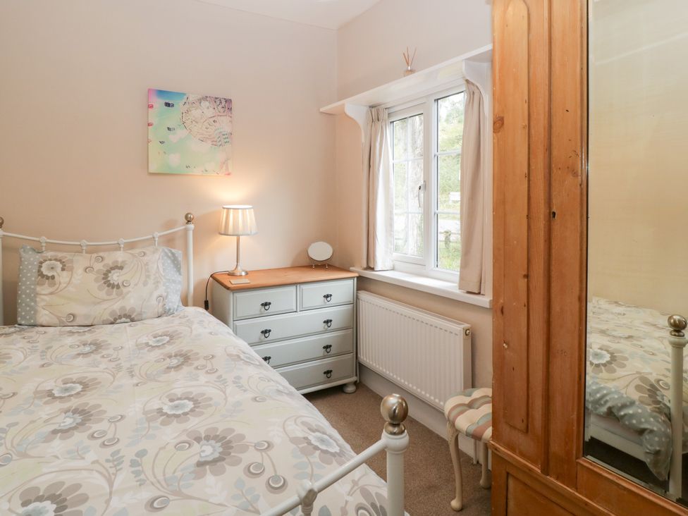A bedroom with a bed, chest of drawers, and window at The Croft in Vowchurch near Peterchurch