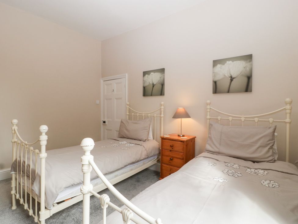 A bedroom with two beds and a nightstand at The Croft in Vowchurch near Peterchurch