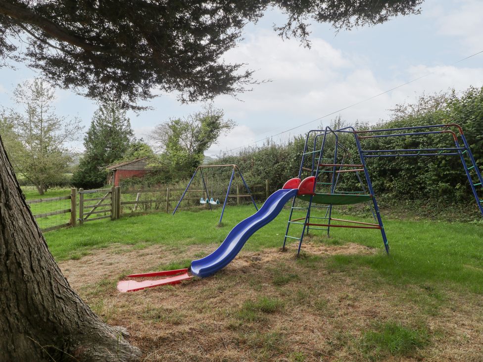 A playground with a slide and swingset in a garden at The Croft Vowchurch near Peterchurch