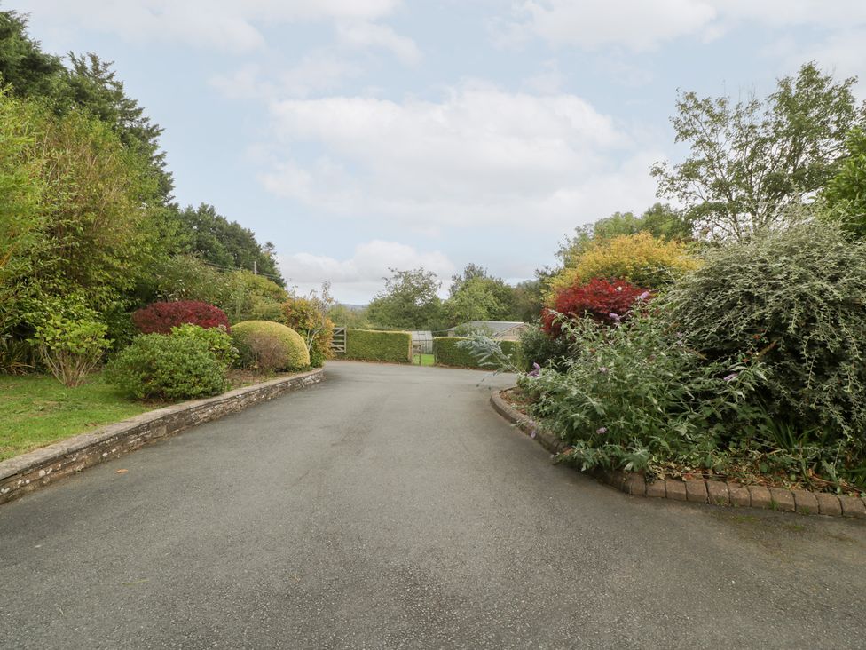 A driveway surrounded by bushes and a gate at The Croft in Vowchurch near Peterchurch