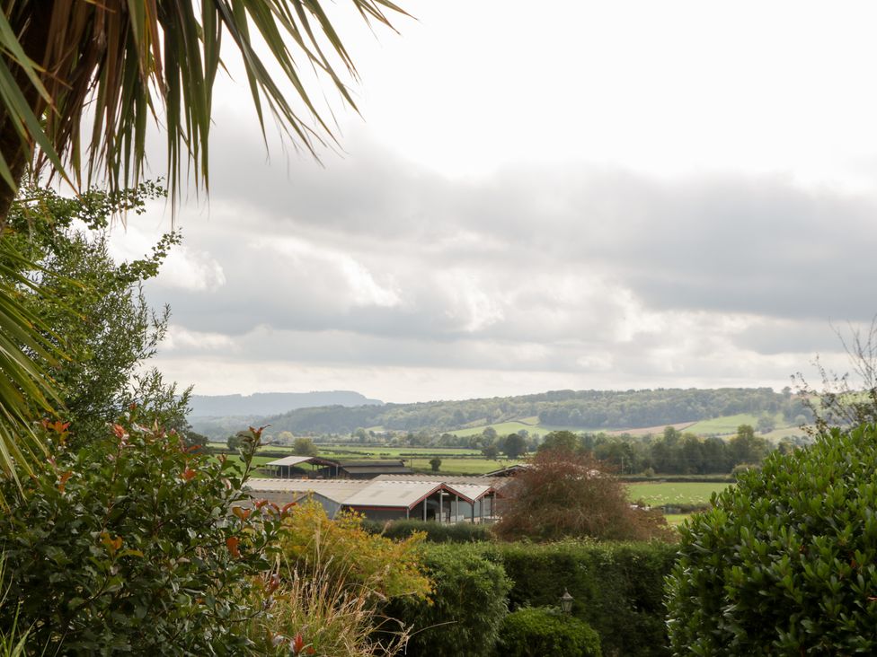 A view of fields and buildings under a cloudy sky at The Croft in Vowchurch near Peterchurch