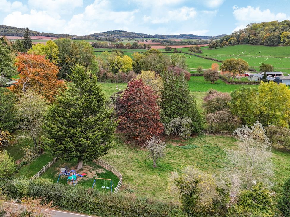 An outdoor area with trees and playground equipment at The Croft in Vowchurch near Peterchurch