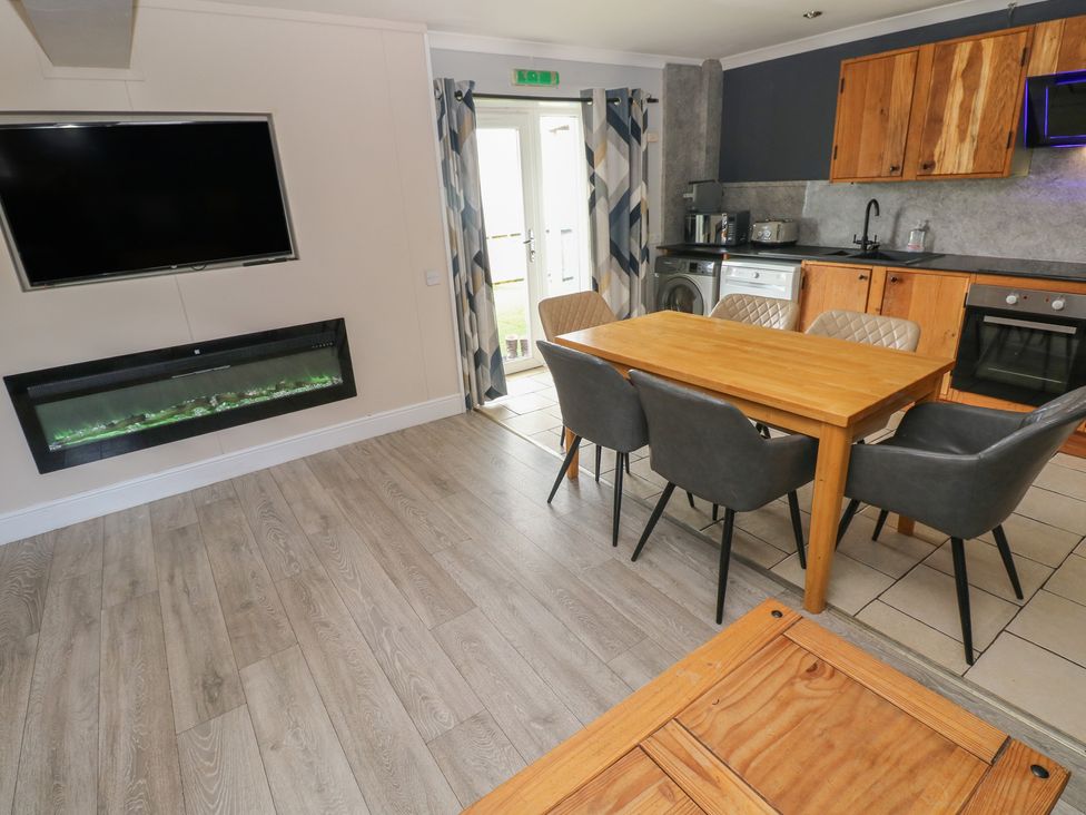 A kitchen with a dining table and appliances at Dylan's Court in Laugharne