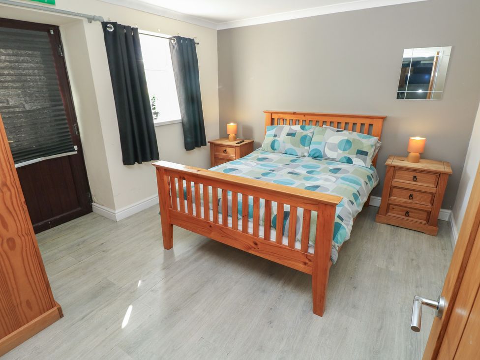 A bedroom with a bed and bedside tables at Dylan's Court in Laugharne
