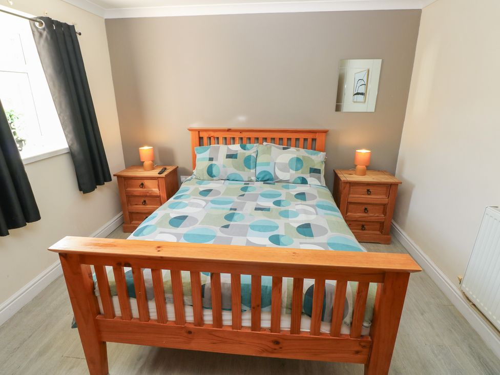 A bedroom with a wooden bed and nightstands at Dylan's Court in Laugharne