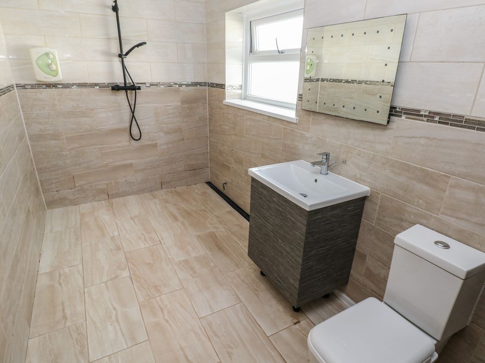 A bathroom with a shower, sink, and toilet at Dylan's Court in Laugharne