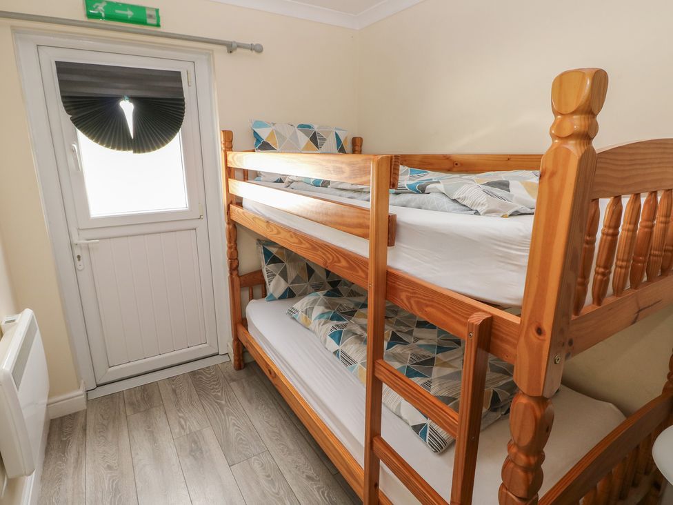 A bedroom with a bunk bed and a door at Dylan's Court in Laugharne