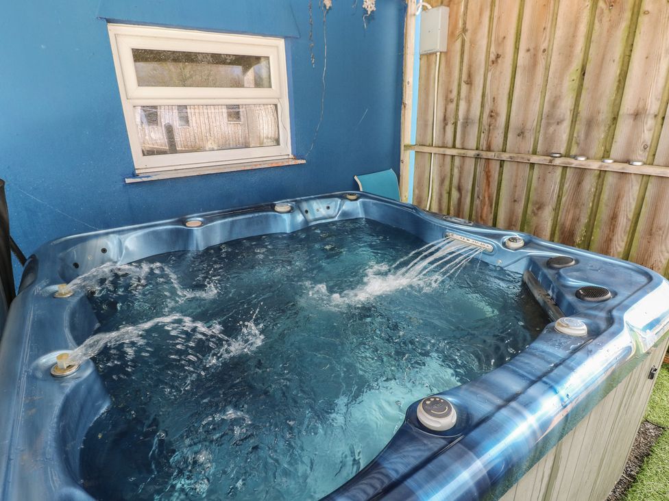 A hot tub in a fenced outdoor area at Dylan's Court in Laugharne