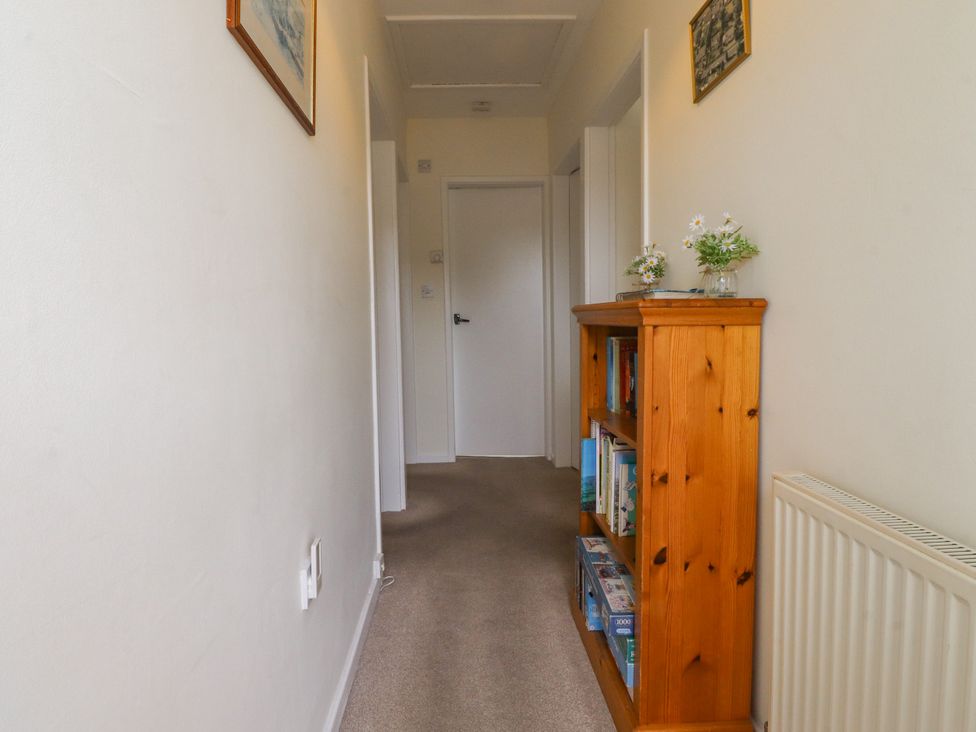 A hallway with a bookshelf and flowers at Wynnville in Embsay near Skipton