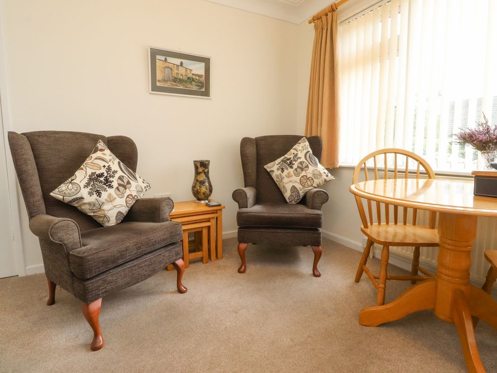 A living room with armchairs and a table at Wynnville in Embsay near Skipton