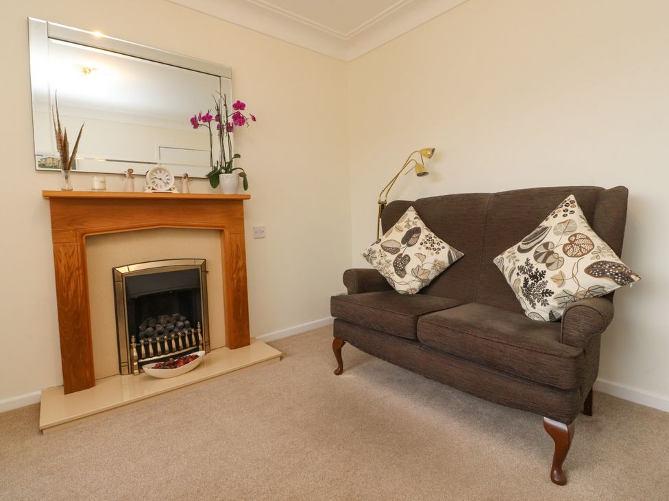 A living room with a sofa and fireplace at Wynnville in Embsay near Skipton