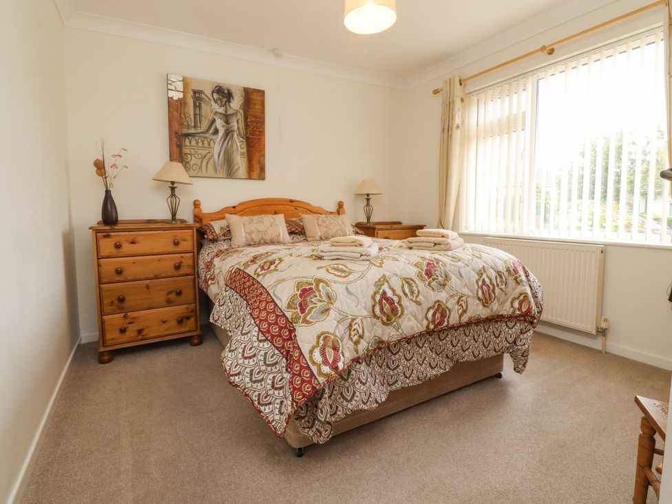 A bedroom with a bed and wooden furniture at Wynnville in Embsay near Skipton