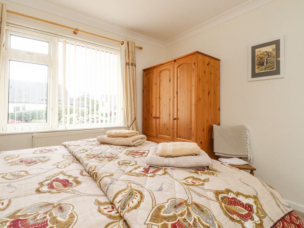 A bedroom with a bed and a wardrobe at Wynnville in Embsay near Skipton