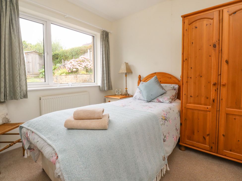 A bedroom with a bed and wardrobe at Wynnville in Embsay near Skipton