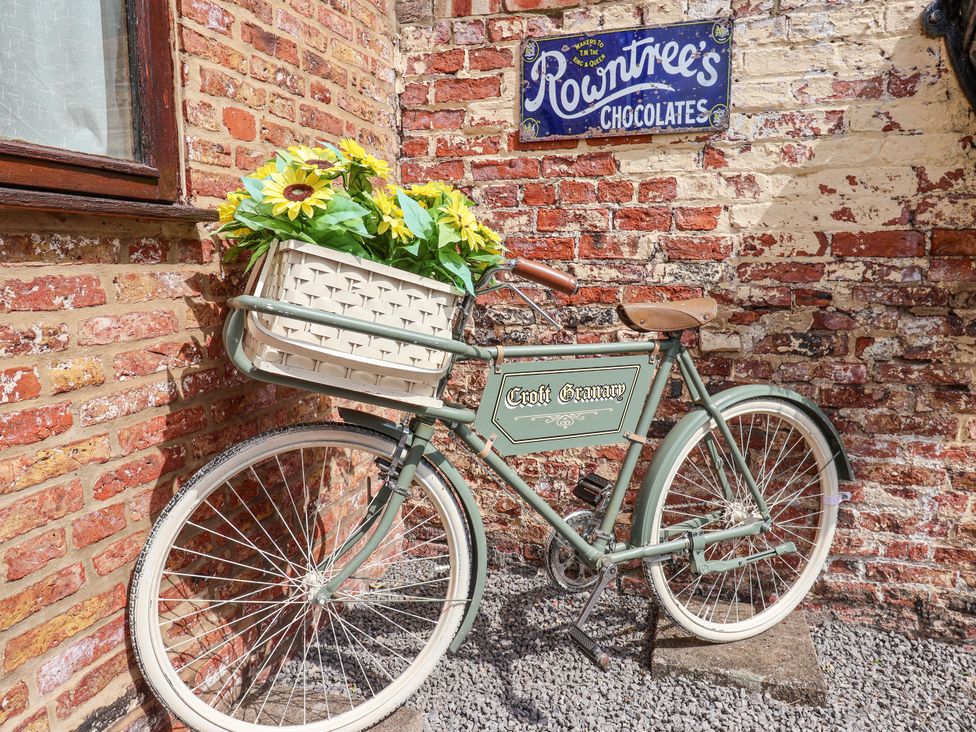 A bicycle with a basket of flowers near a brick wall at Croft Granary Stillington near Easingwold and York