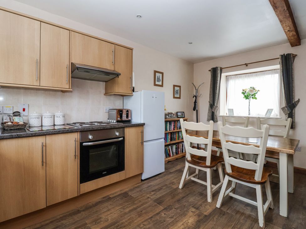 A kitchen with cabinets and dining table at Croft Granary in Stillington near Easingwold and York