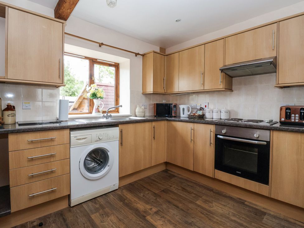 A kitchen with wooden cabinets and appliances at Croft Granary Stillington near Easingwold and York