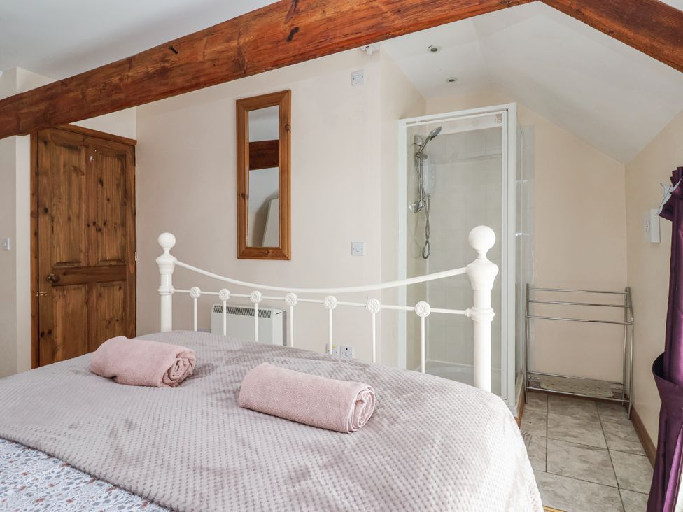 A bedroom with a bed and shower area at Croft Granary in Stillington near Easingwold and York