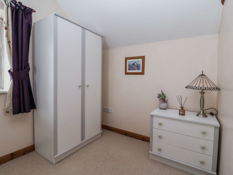 A bedroom with a wardrobe and a lamp at Croft Granary Stillington near Easingwold and York