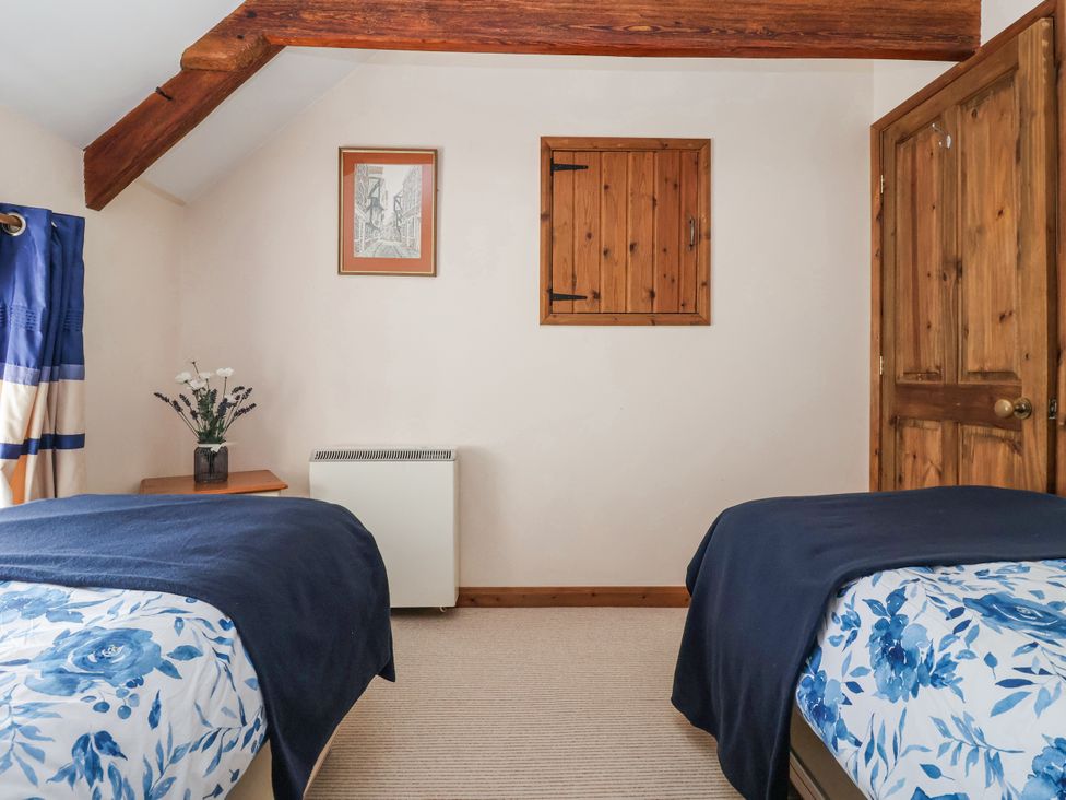 A bedroom with two beds and a bedside table at Croft Granary Stillington near Easingwold and York