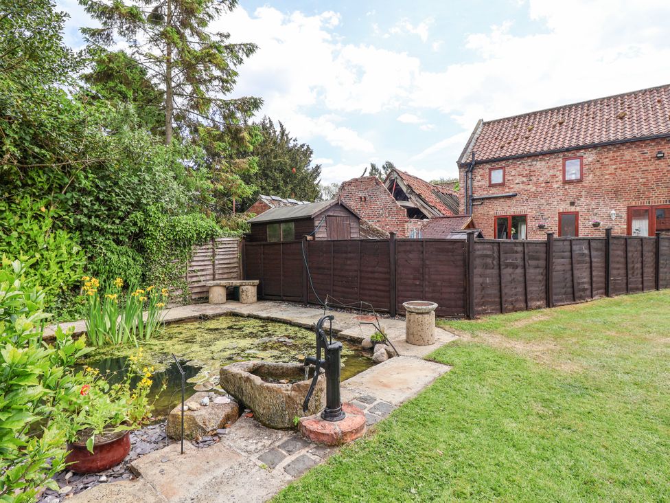 A garden with a pond and a pump at Croft Granary Stillington near Easingwold and York